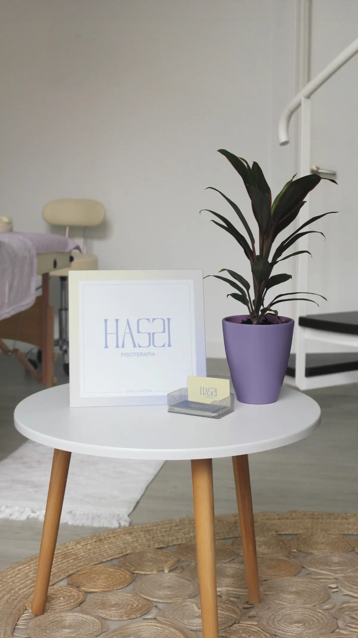Sala de Haszi Fisioterapia con una mesa auxiliar, una planta y material de tratamiento.