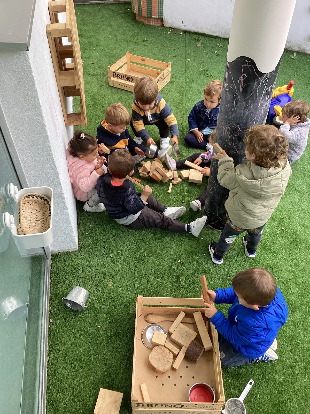 Grupo de niños juega con bloques de madera en el patio de Haurreskola Karmeltxo.