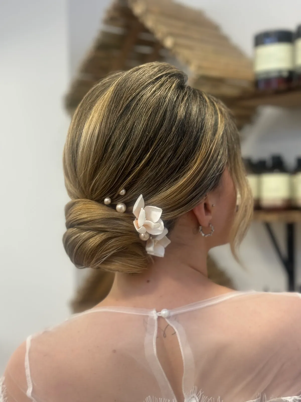 Recogido bajo con adorno floral y perlas en el cabello, realizado en Hirune Ile-Apaindegia.