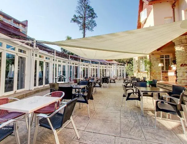 Terraza exterior del Hotel Harrison Etxea con mesas bajo un toldo