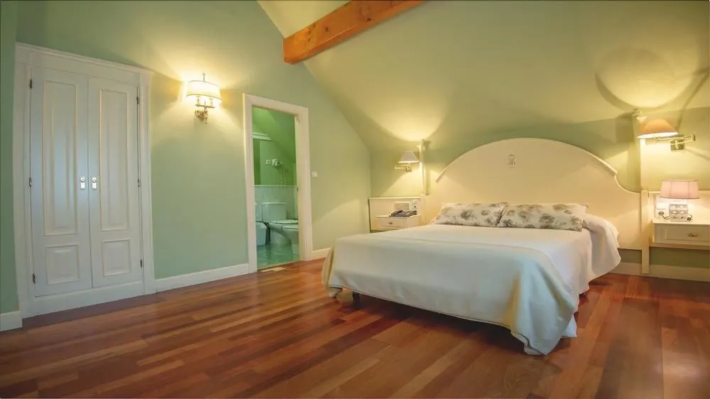 Habitación del Hotel Harrison Etxea con cama doble y vigas de madera