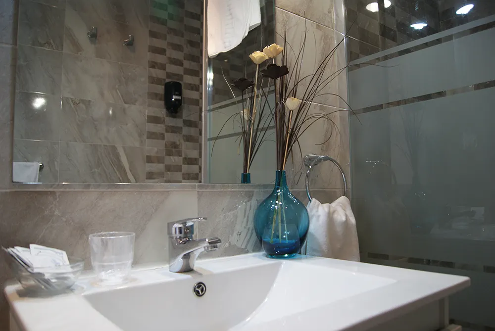 Baño del Hotel San Blas con lavabo y ducha acristalada.