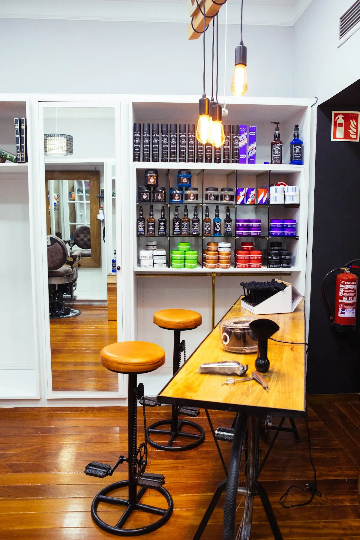 Mostrador de Ibra,s barber shop con productos de peluquería y taburetes.