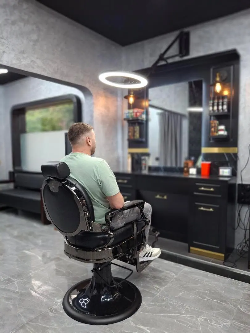 Cliente sentado en un sillón de barbería de ICON Barber Studio
