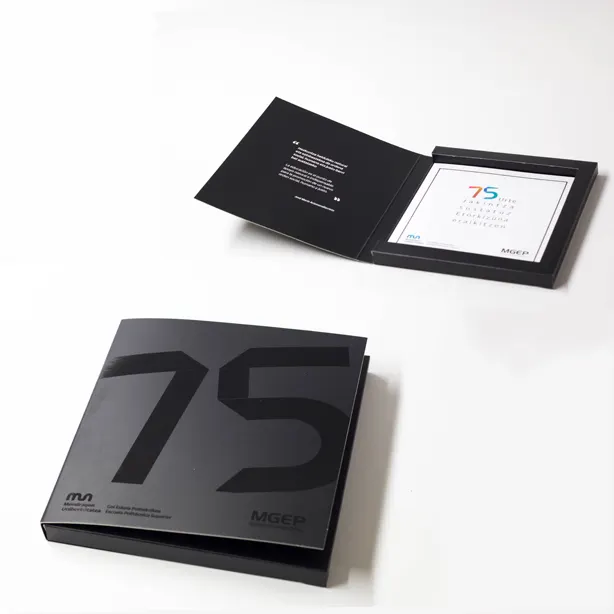 Estuche impreso con el número 75 y una tarjeta en su interior, ejemplo de trabajo gráfico de Ikusgraf.