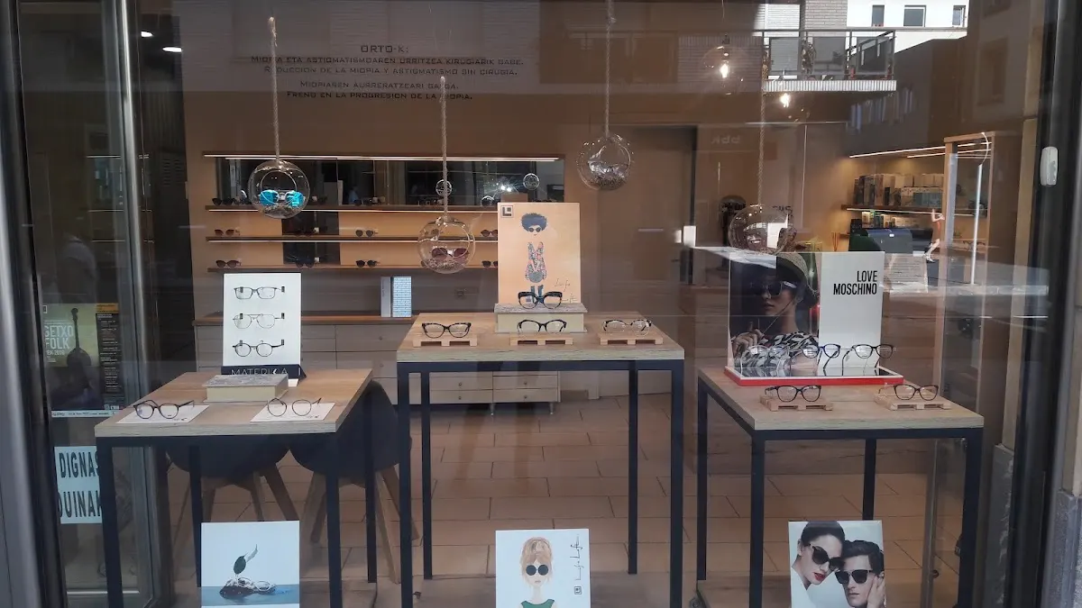 Escaparate de IKUSMEN OPTIKA con gafas expuestas en mesas y estanterías.