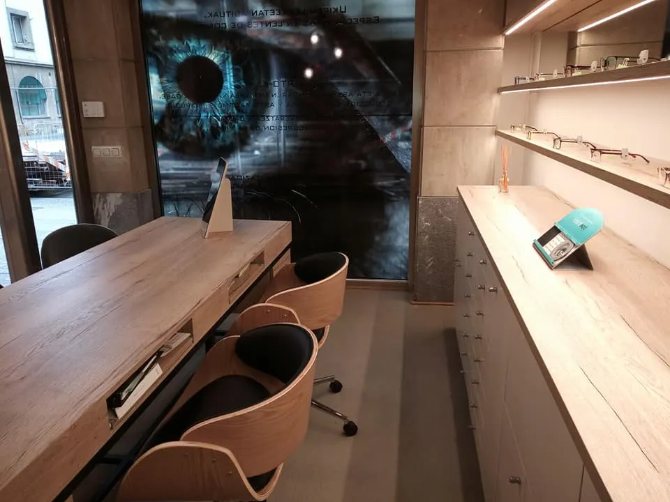 Interior de IKUSMEN OPTIKA con mostrador de gafas y zona de atención.
