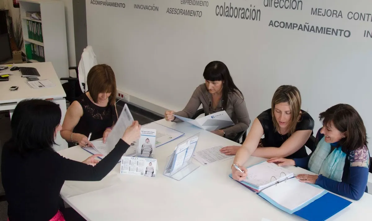 Personas reunidas en una mesa de trabajo en las oficinas de In & Out