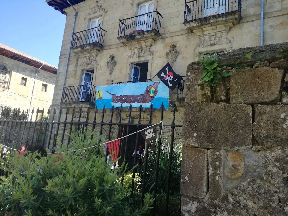 Fachada de una casa tradicional con balcones y banderas