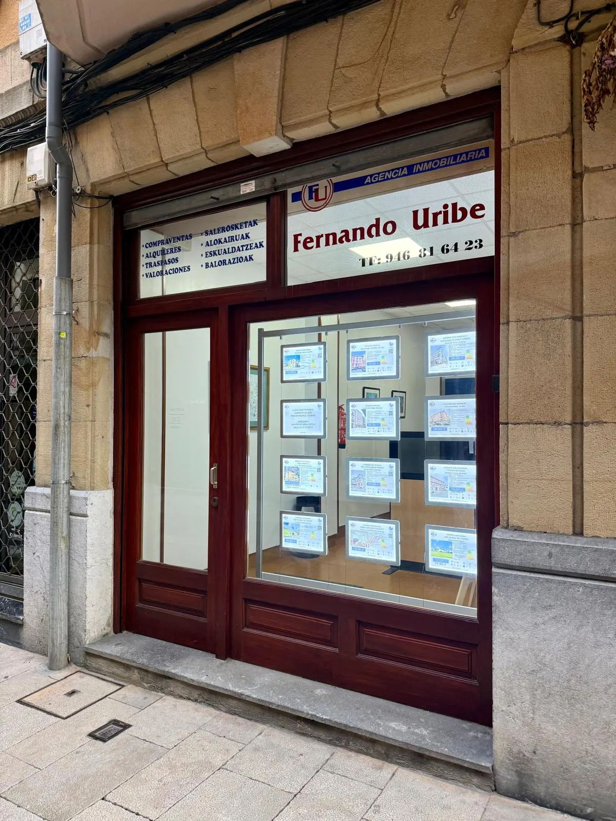 Fachada de la oficina de Inmobiliaria Fernando Uribe en Durango, con anuncios de viviendas en el escaparate
