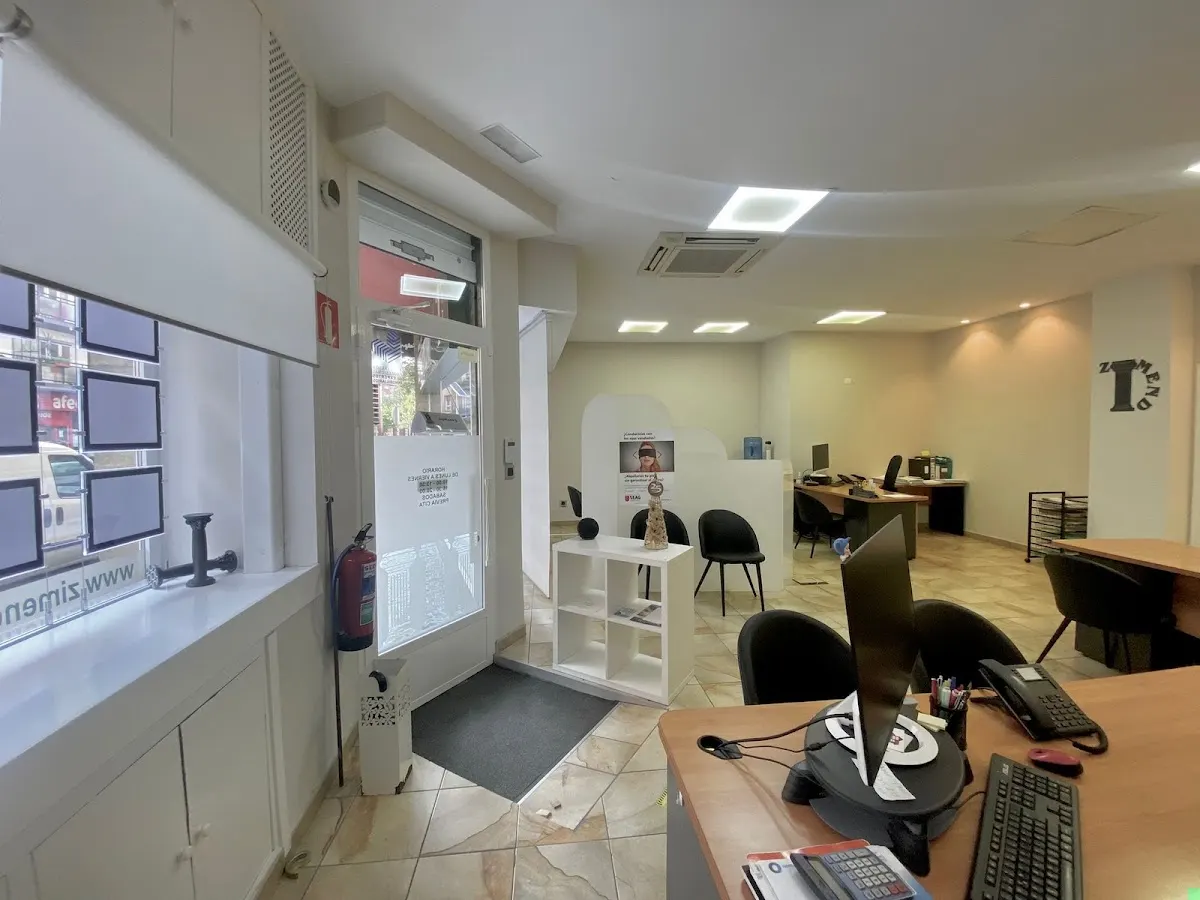 Interior de la oficina de Inmobiliaria Zimendi, con puestos de atención al público.
