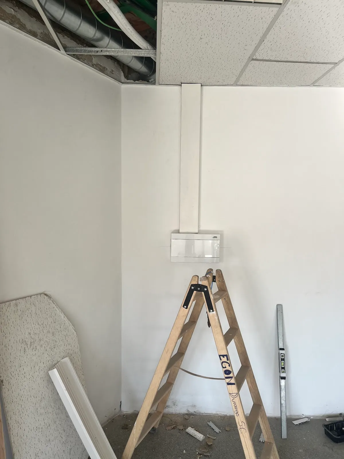 Trabajo de instalación eléctrica en una estancia, con escalera y canaleta.