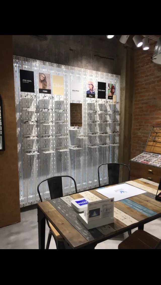 Interior del Instituto Óptico Auditivo, con expositores de gafas y una mesa de atención.