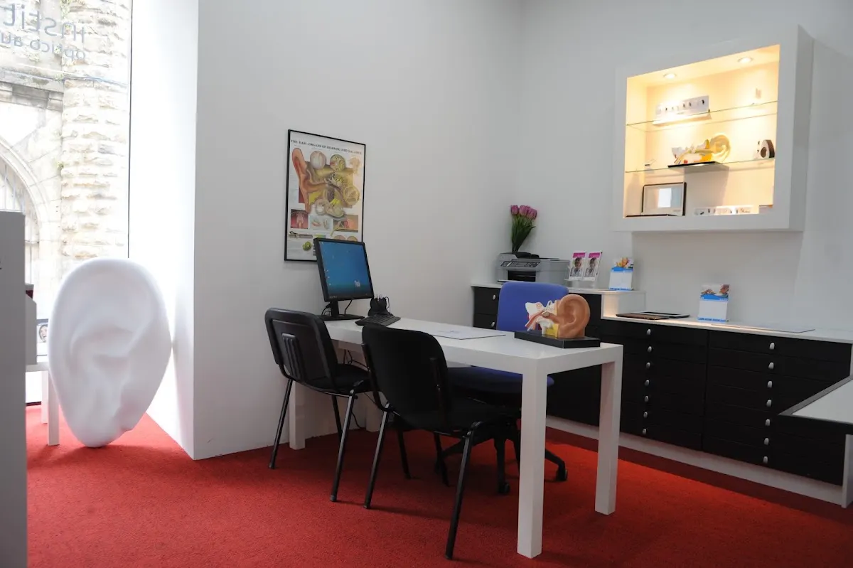 Sala de atención del Instituto Óptico Auditivo, con mesa de consulta y zona de recepción.