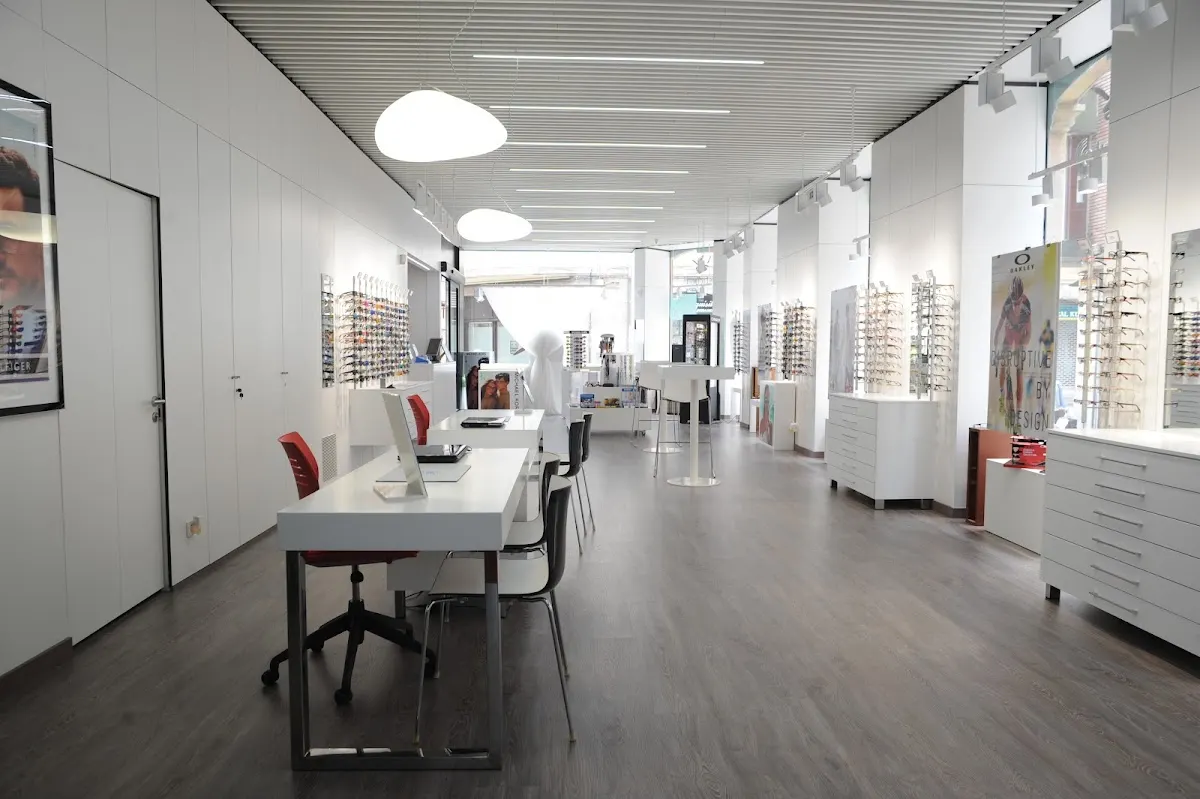 Interior del Instituto Óptico Auditivo con expositores de gafas y mesas de atención.