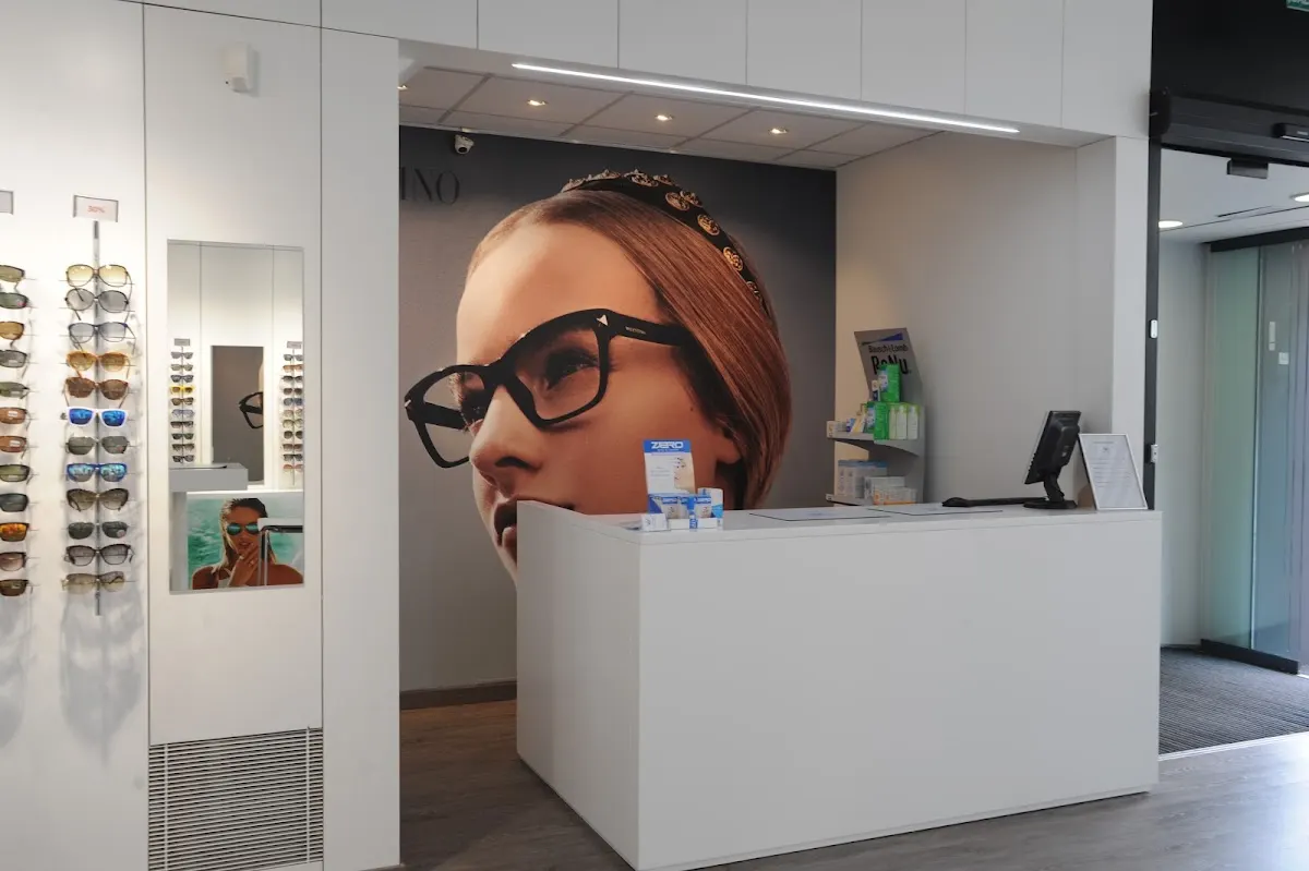 Mostrador de recepción del Instituto Óptico Auditivo junto a una exposición de gafas.