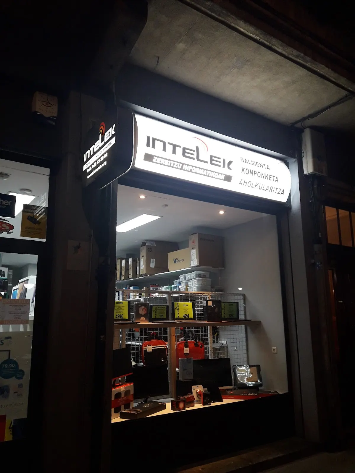 Escaparate de Intelek con el rótulo luminoso y equipos informáticos expuestos