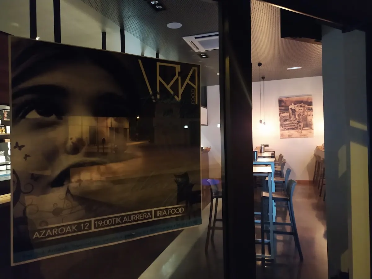 Entrada y comedor de Iria Food, con una mesa junto a la fachada acristalada.