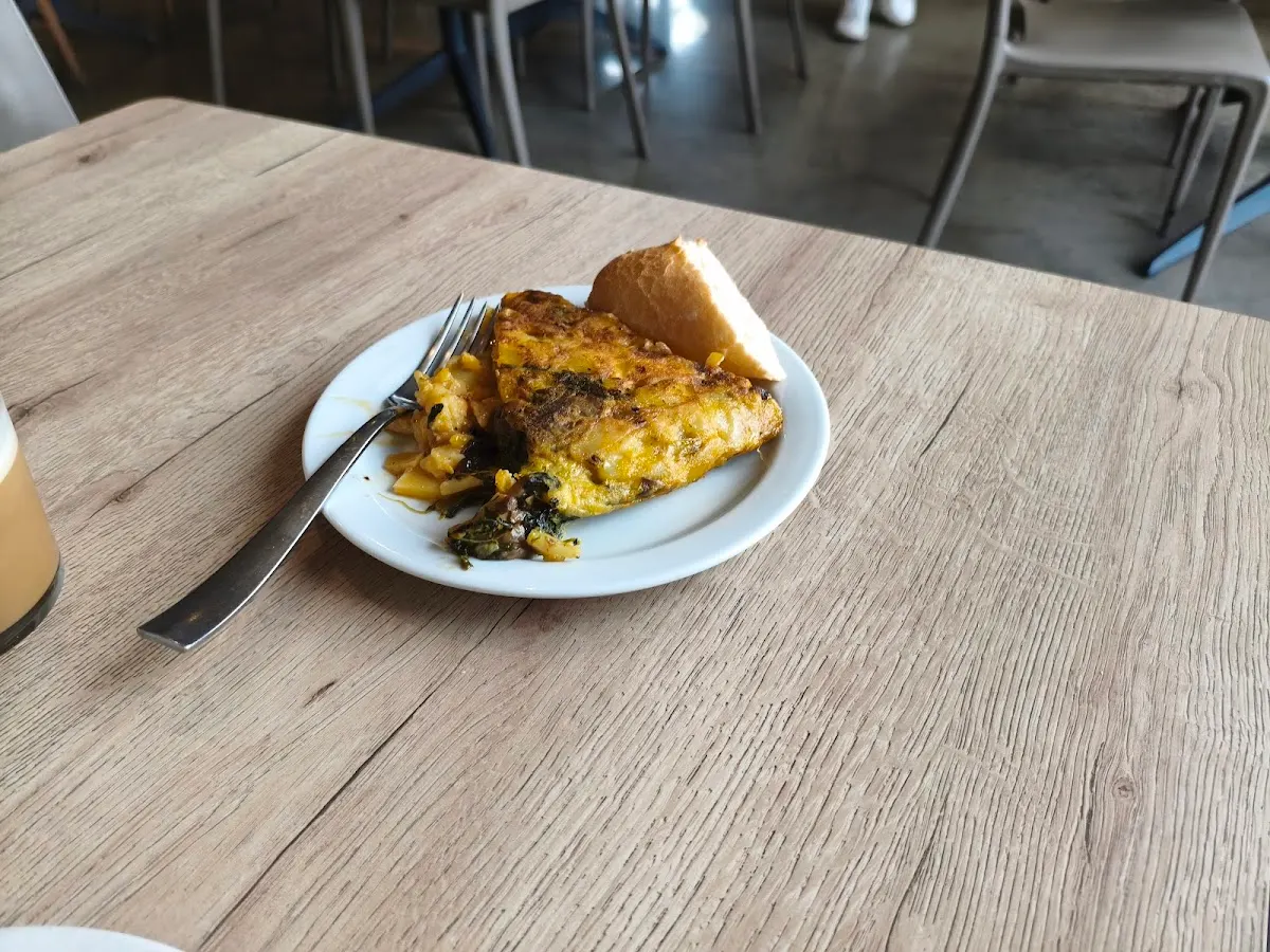 Porción de tortilla con pan servida en una mesa de Iria Food.