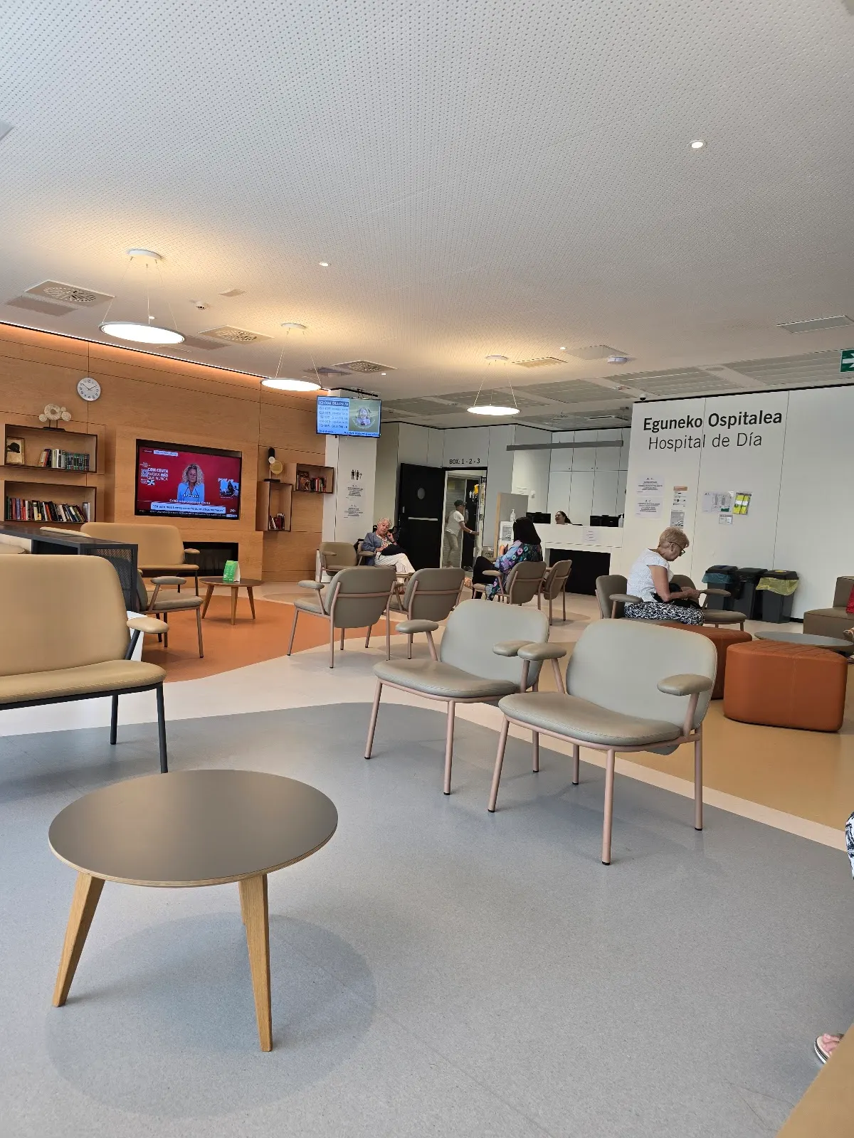 Sala de espera de un hospital de día, con sillas y mesas.