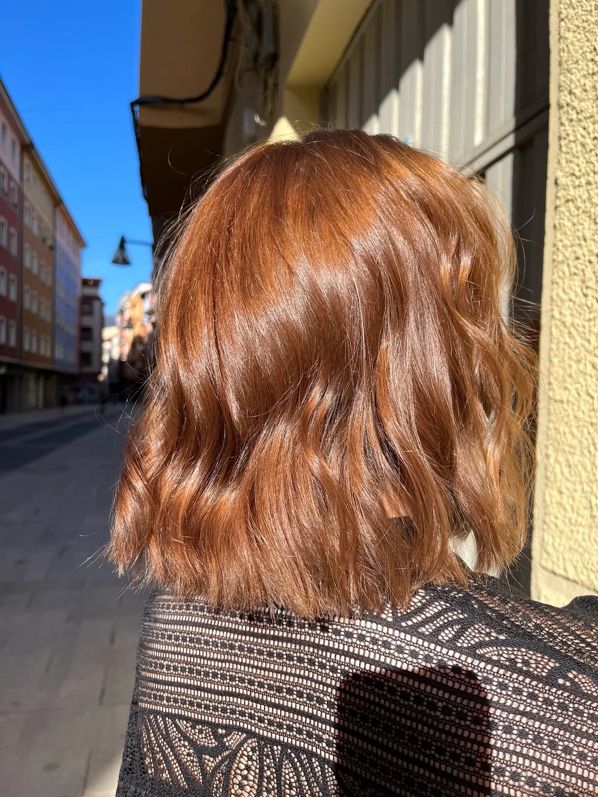 Cabello ondulado cobrizo visto desde atrás en una calle de Durango.