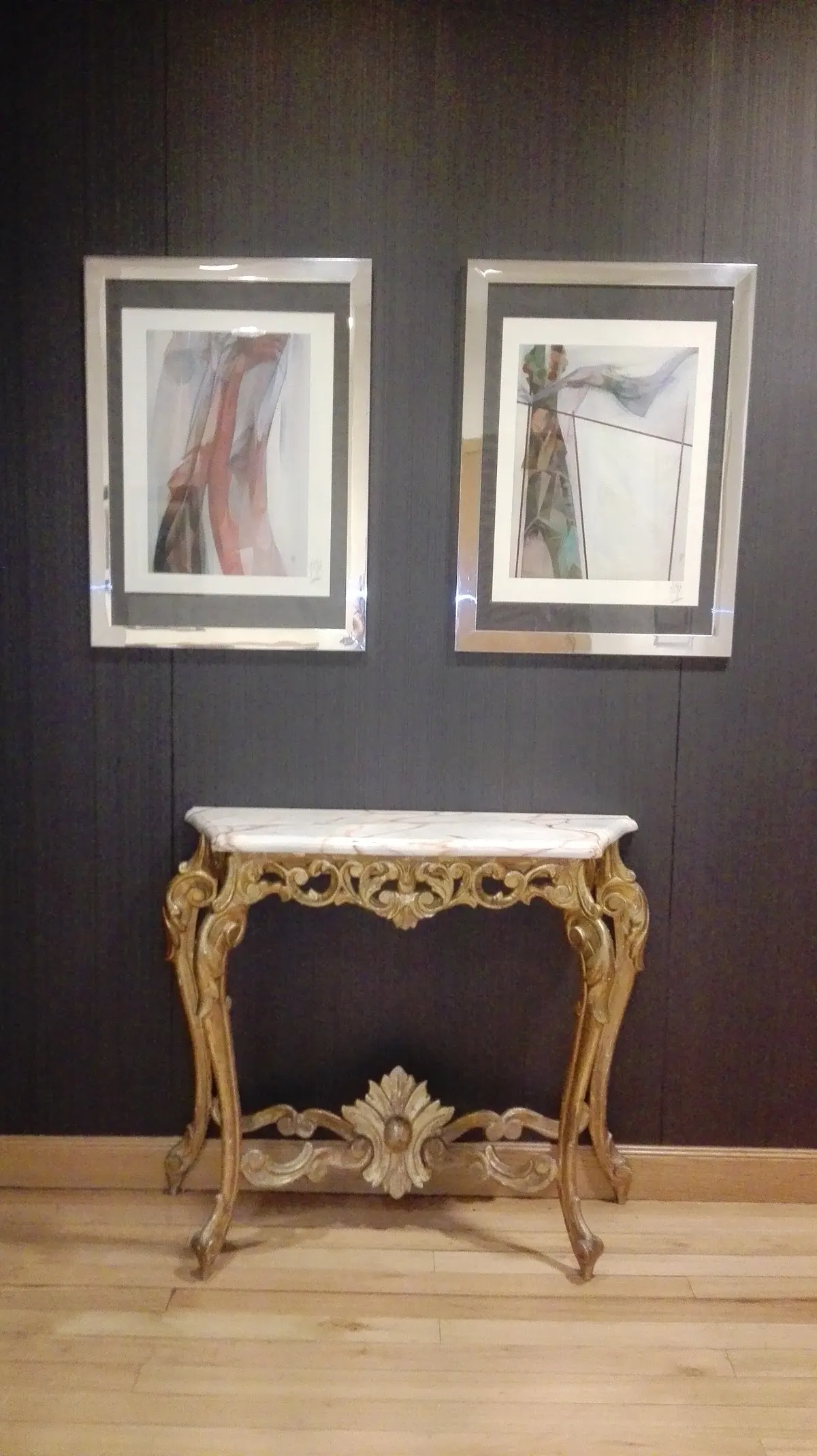 Cuadros y consola decorativa en el interior de la consulta.