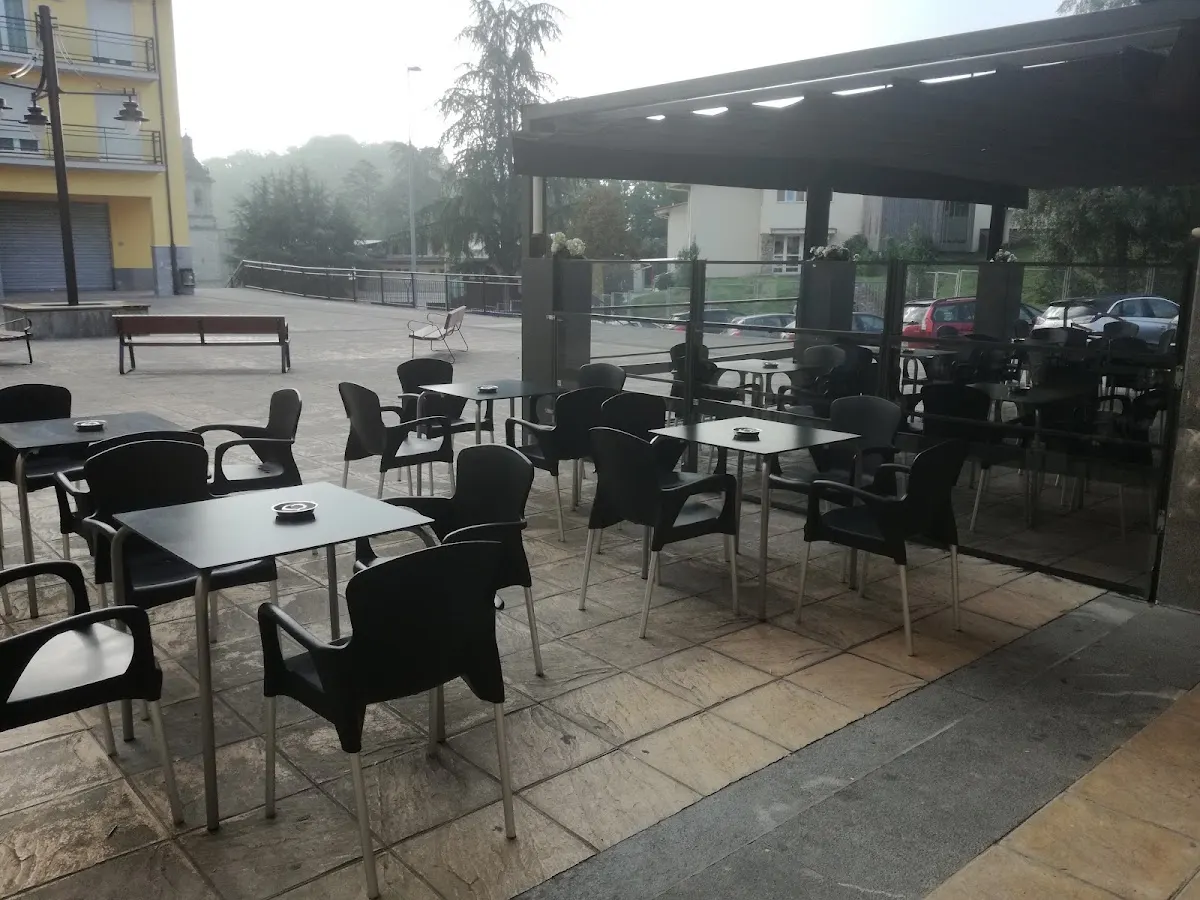 Terraza de Kafe Kantoi con mesas y sillas al aire libre