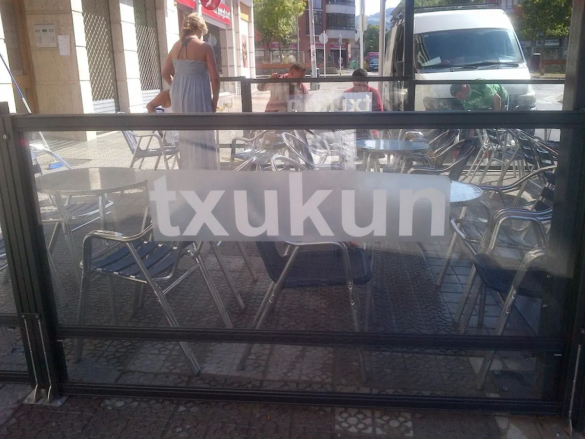 Terraza de Kafeteria Txukun vista desde la calle, con mesas y sillas.