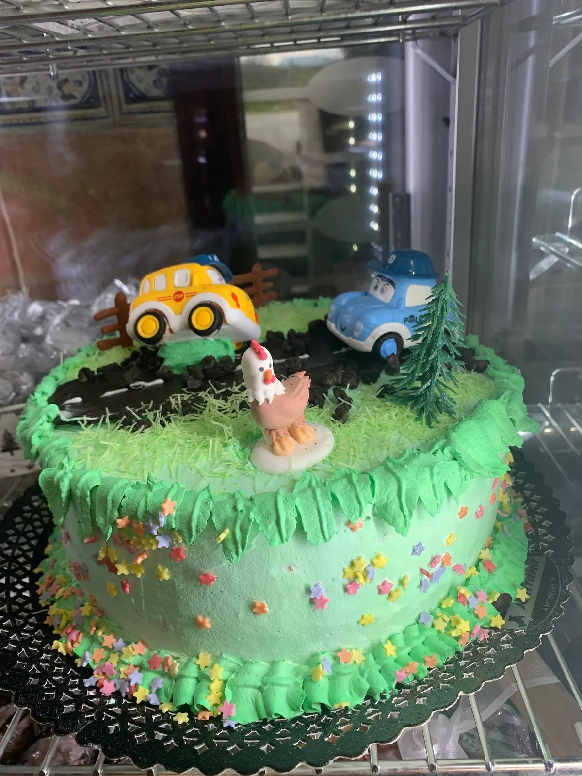 Tarta decorada con figuras de vehículos en el escaparate de Kaitana San Miguel.