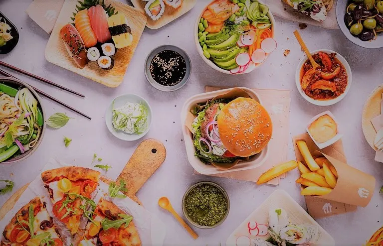 Comida variada, con hamburguesa, patatas fritas, ensaladas y otros platos.