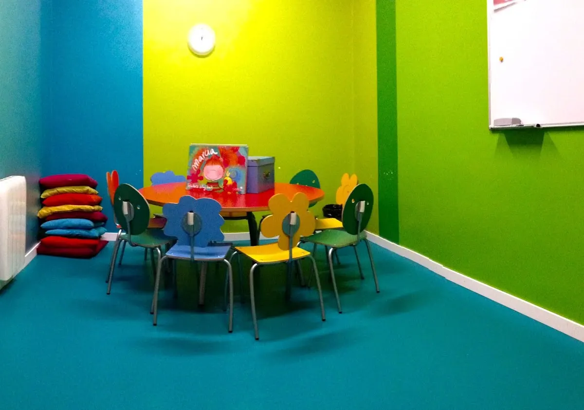 Aula infantil de Kids&Us con mesa, sillas y pizarra