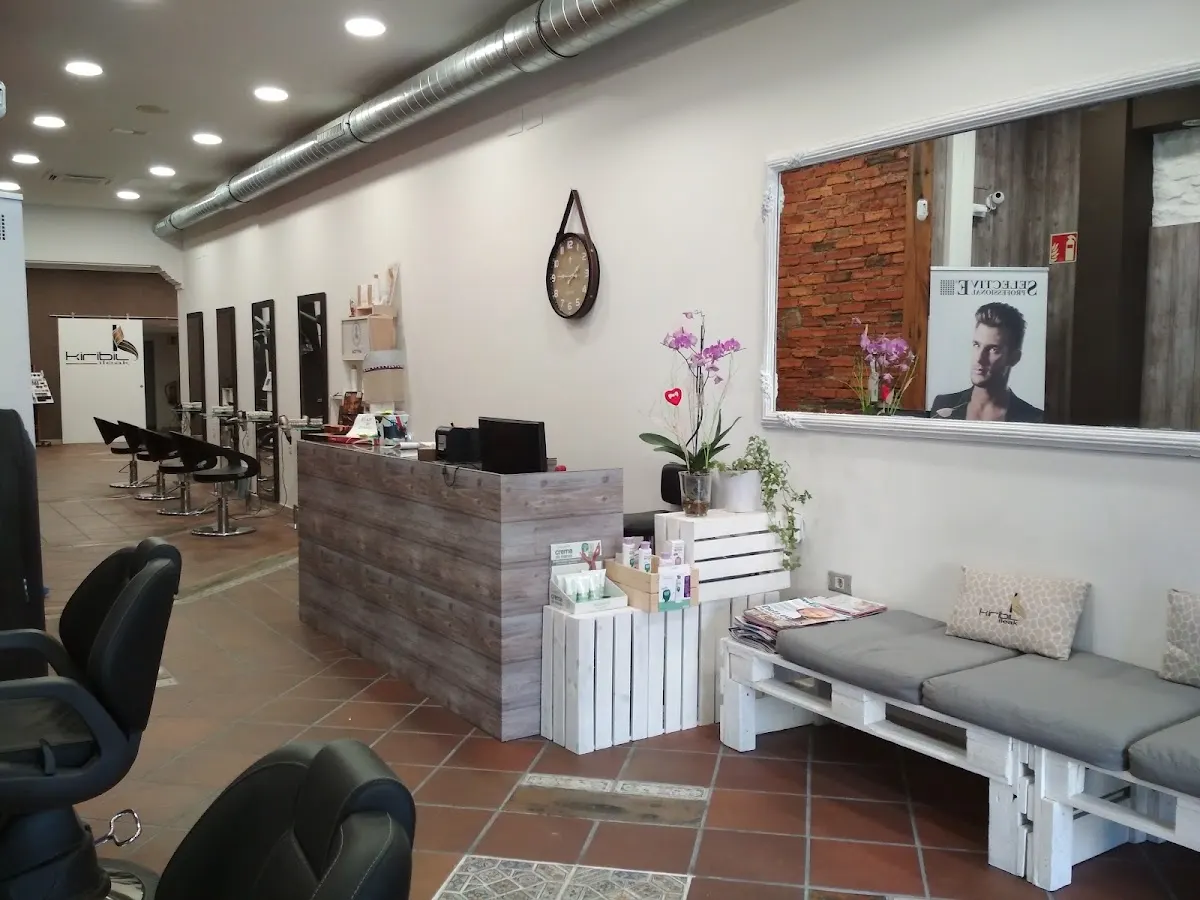 Interior de KIRIBIL ILEAK con mostrador, puestos de peluquería y zona de espera.