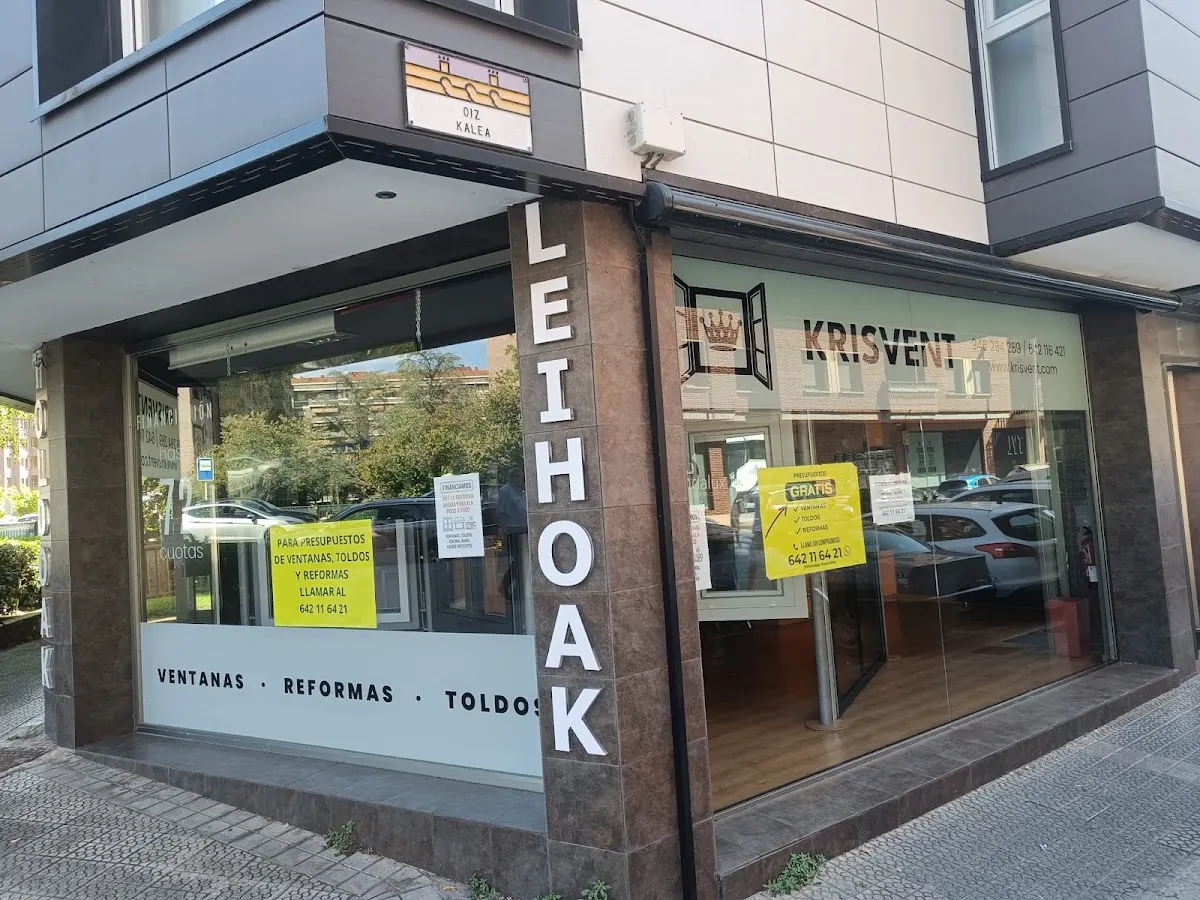 Fachada de la tienda Krisvent, con escaparates y rótulo de ventanas, reformas y toldos