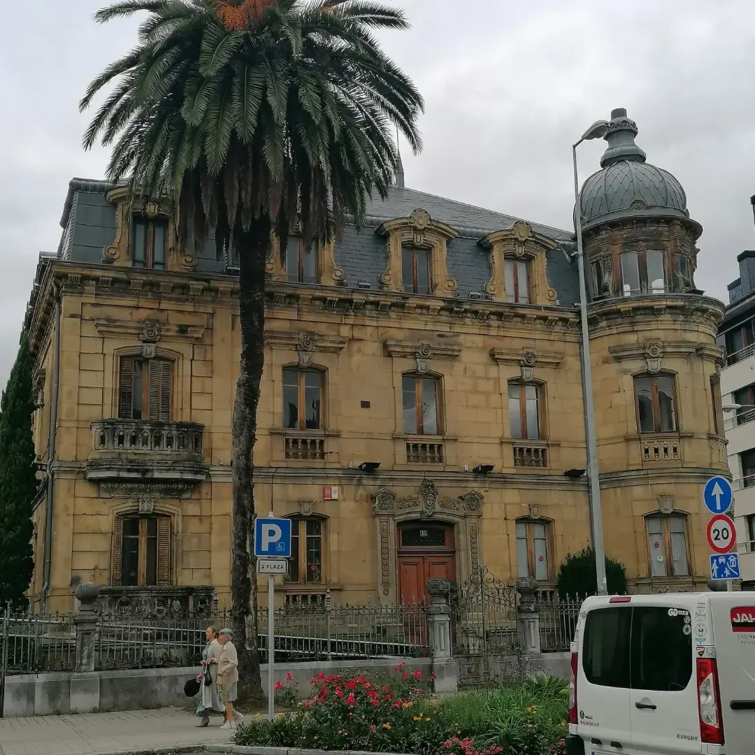 Edificio de Kurutziaga Ikastola en Durango, con una palmera delante.