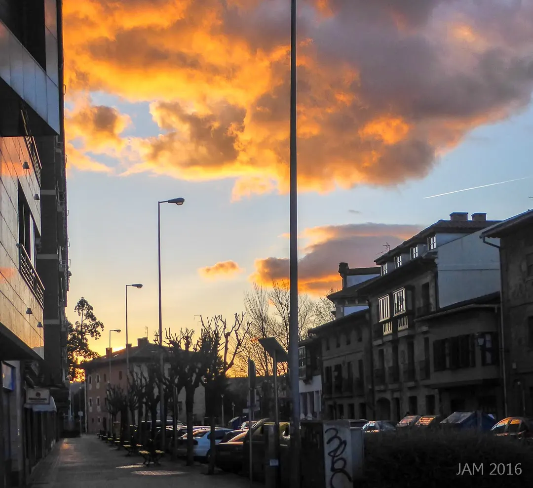 Calle de Durango al atardecer, con edificios y vehículos aparcados.