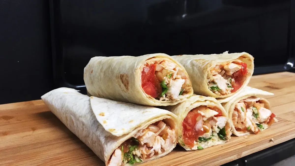 Varios wraps rellenos servidos sobre una tabla de madera.