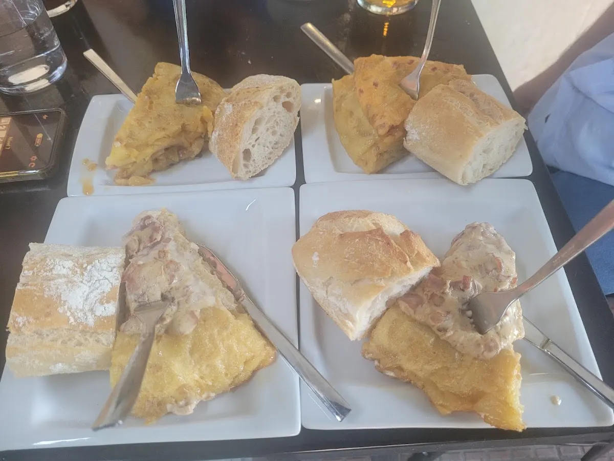 Raciones de tortilla y pan servidas en platos en Landako Taberna.