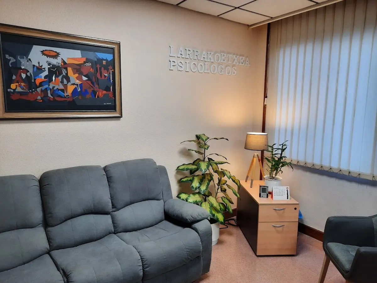 Sala de espera de Larrakoetxea Psicólogos con sofá, cuadro y plantas.