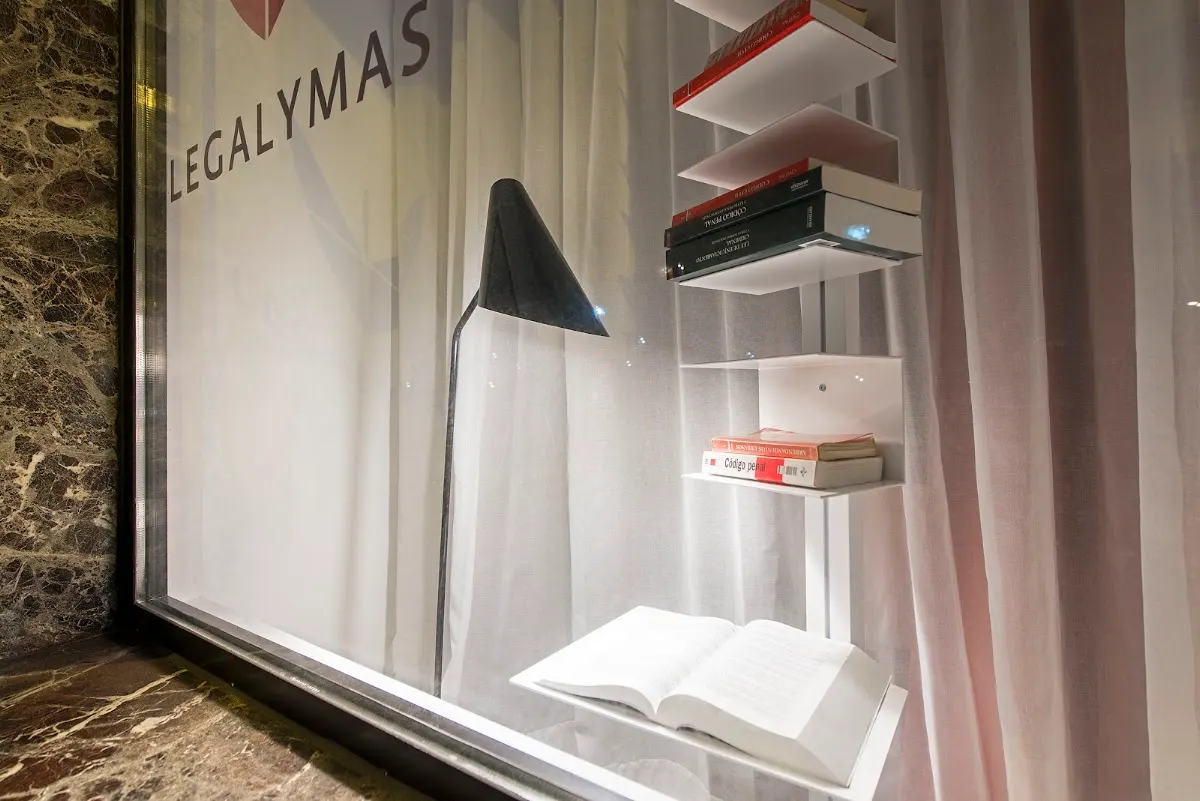 Escaparate de LEGALYMAS con libros y una lámpara de lectura.