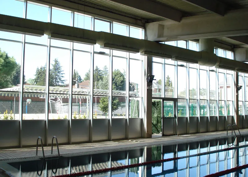 Cerramiento acristalado junto a una piscina cubierta