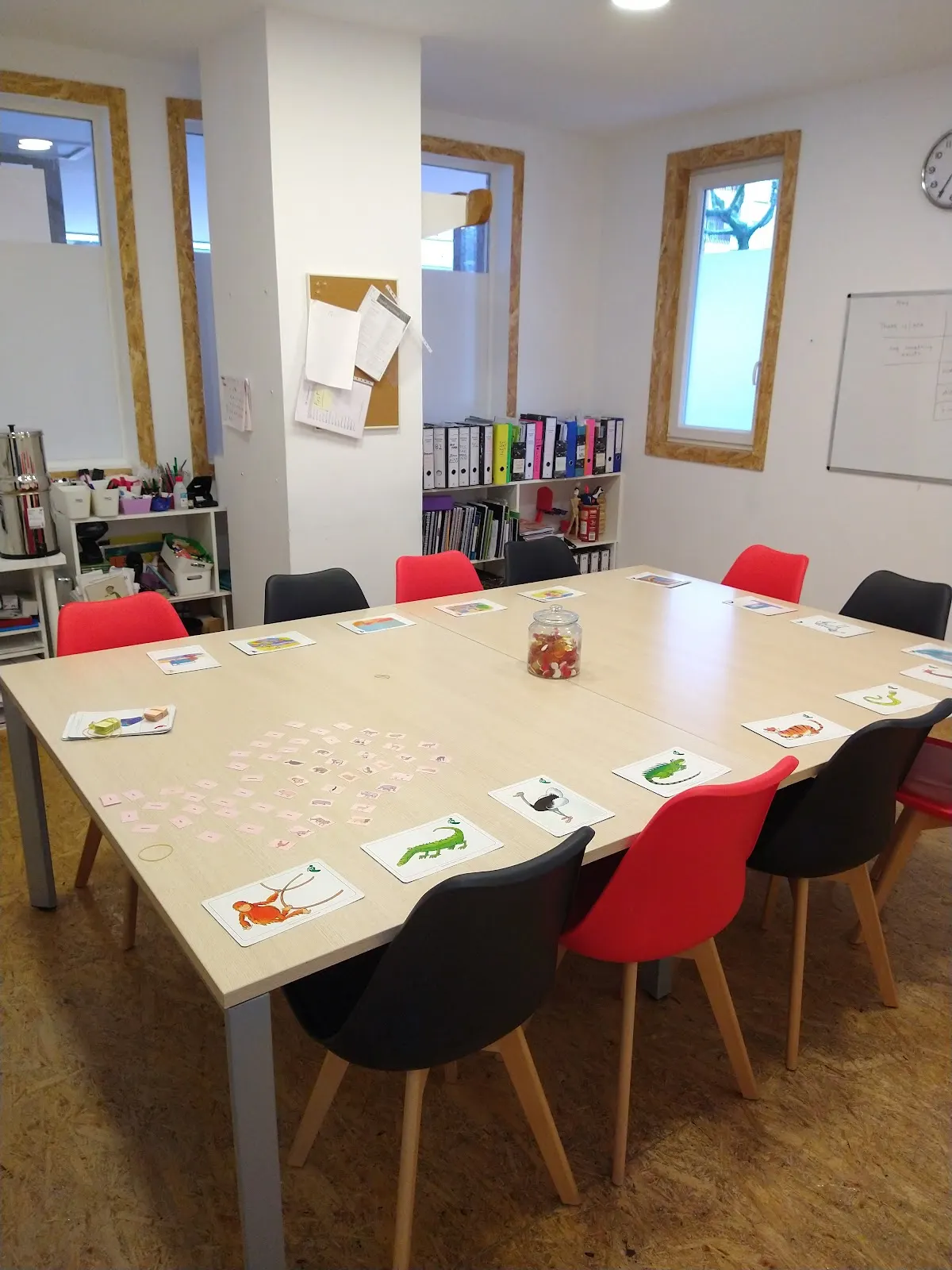 Aula de Let’s Talk con una mesa de actividades y sillas de colores.