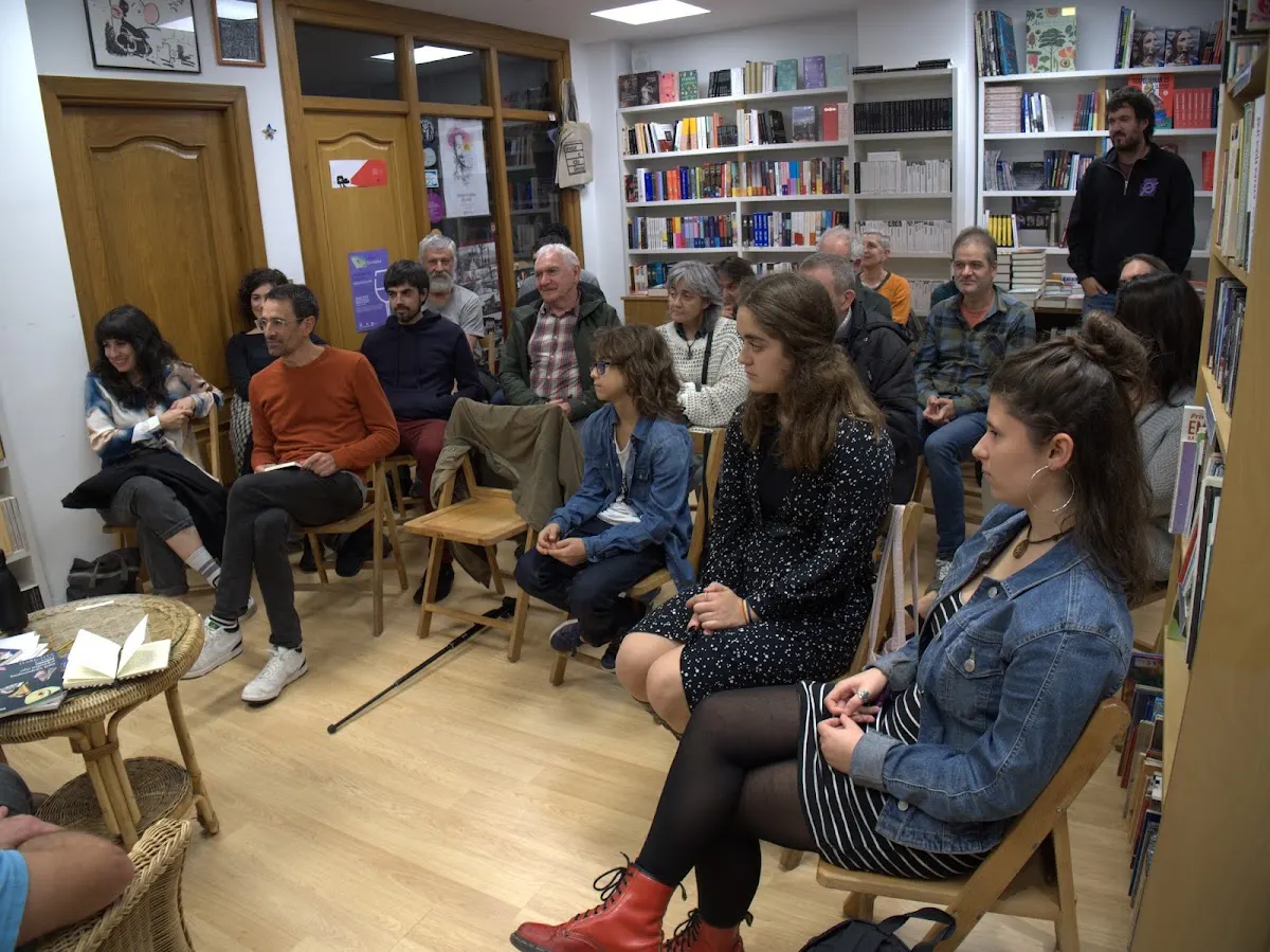 Actividad con asistentes sentados en el interior de Librería Hitz Liburudenda.
