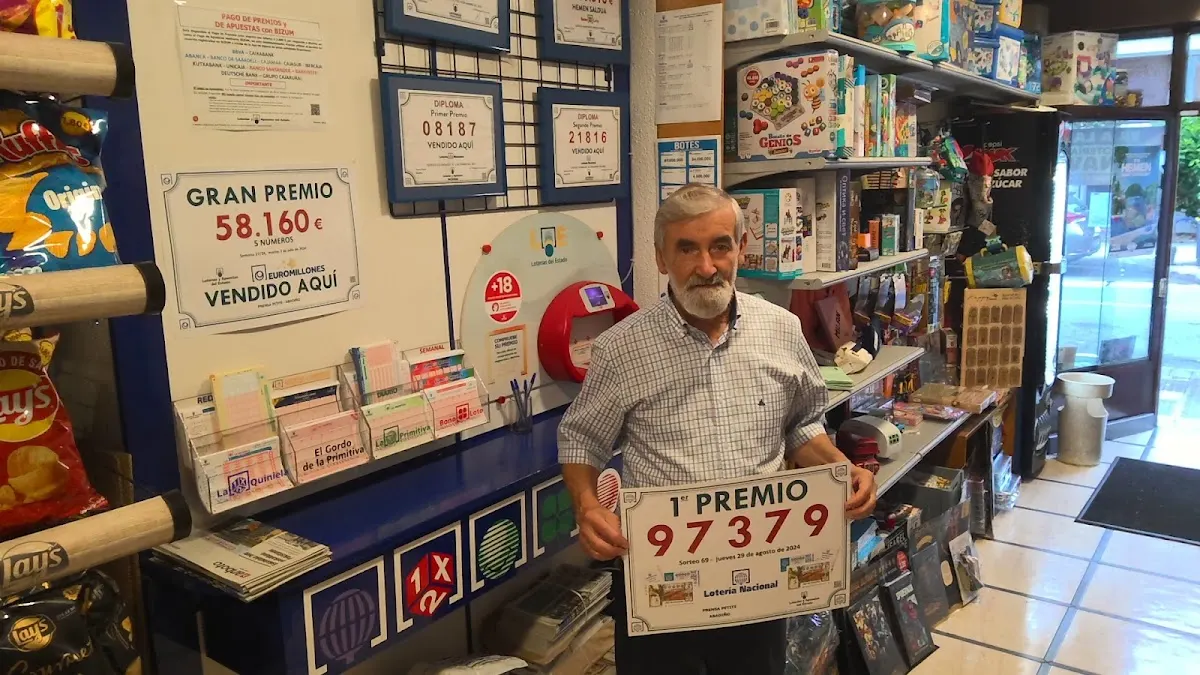 Interior de Librería PETITE con el responsable y un cartel de lotería