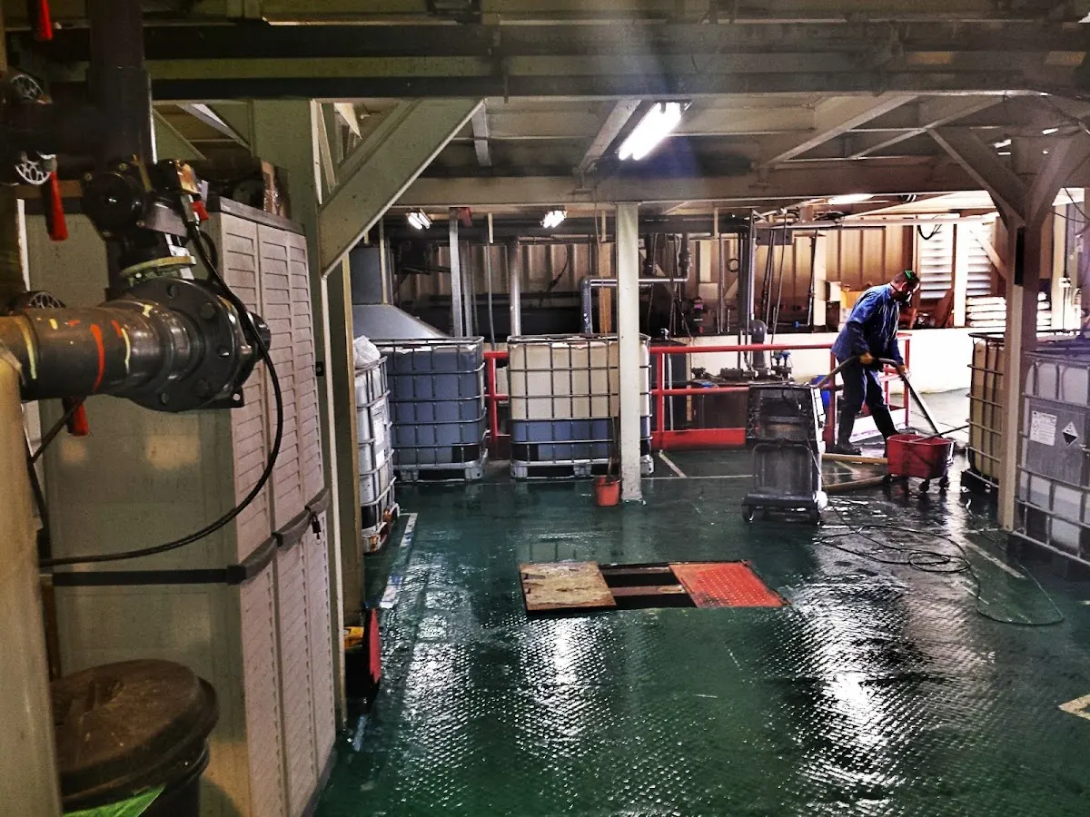 Trabajador realizando labores de limpieza en una instalación industrial
