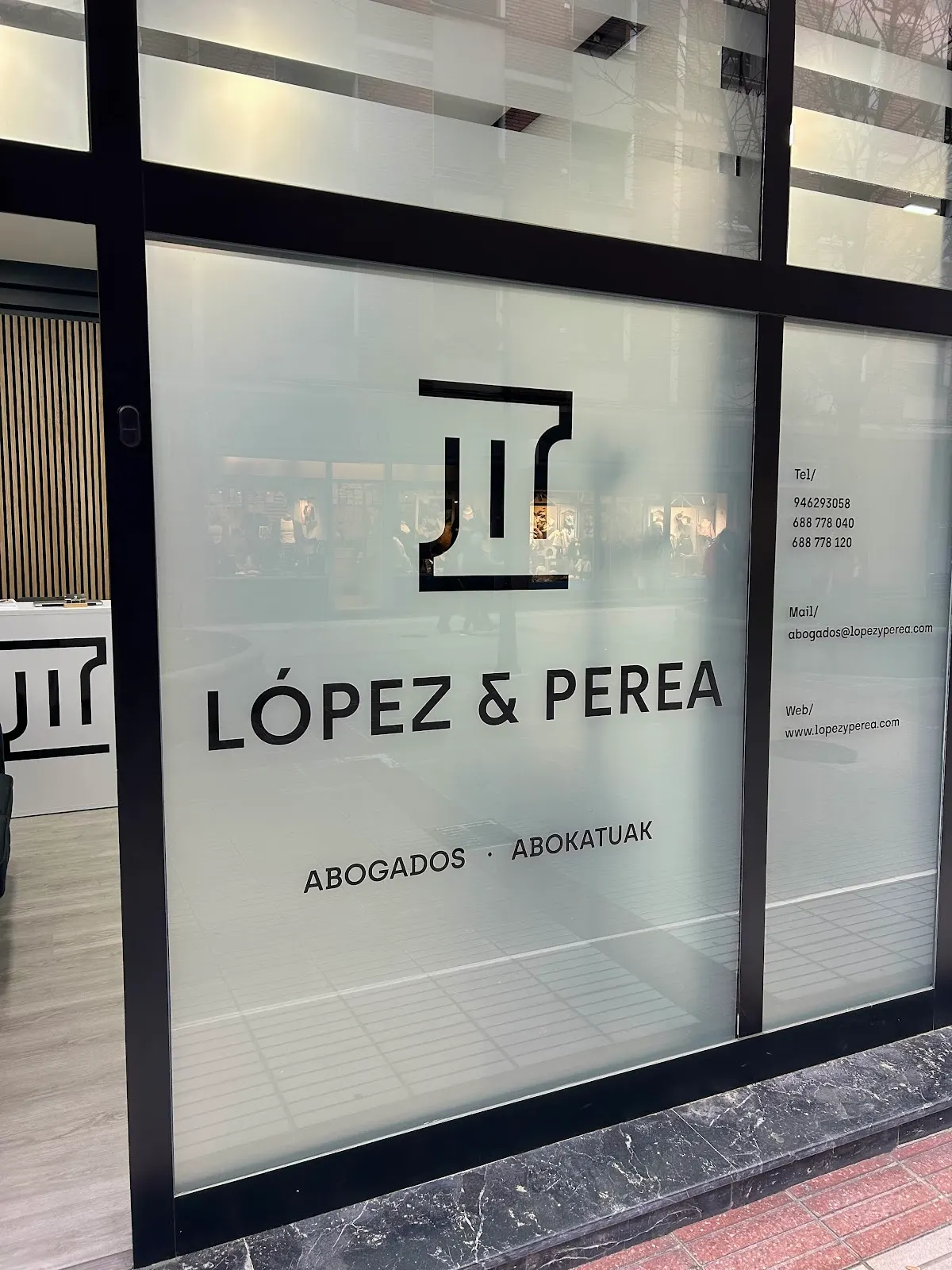 Rótulo de López y Perea Abogados en el escaparate del despacho