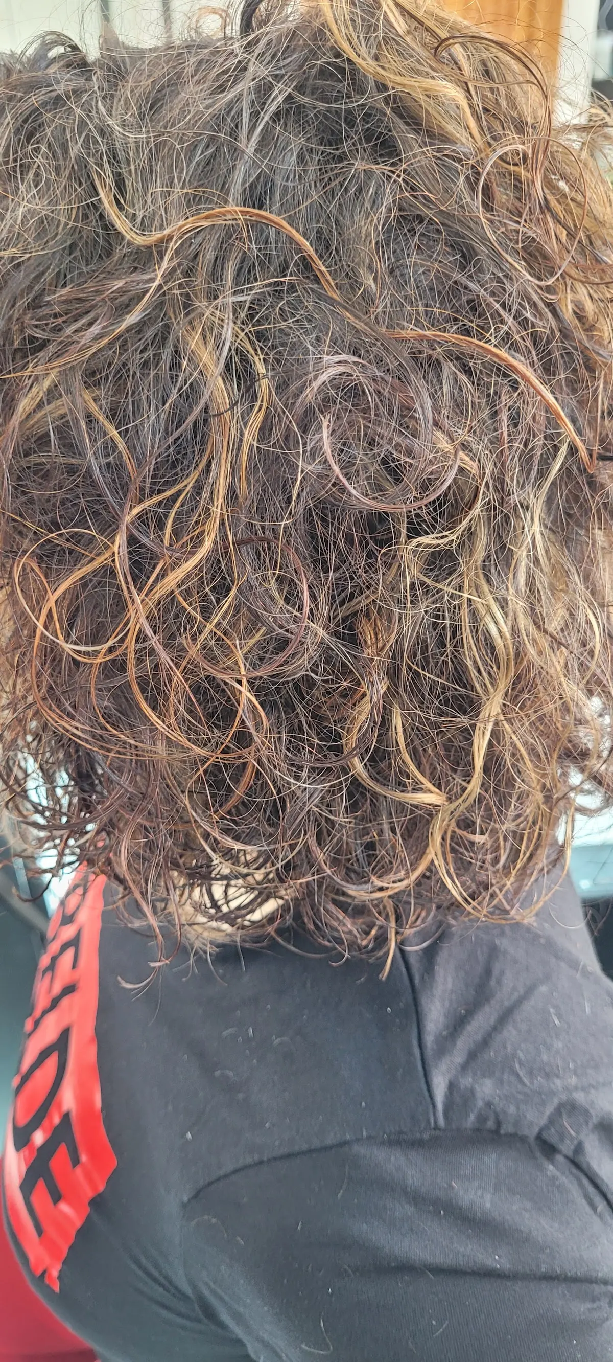 Cabello rizado con reflejos cobrizos en Mada peluquería