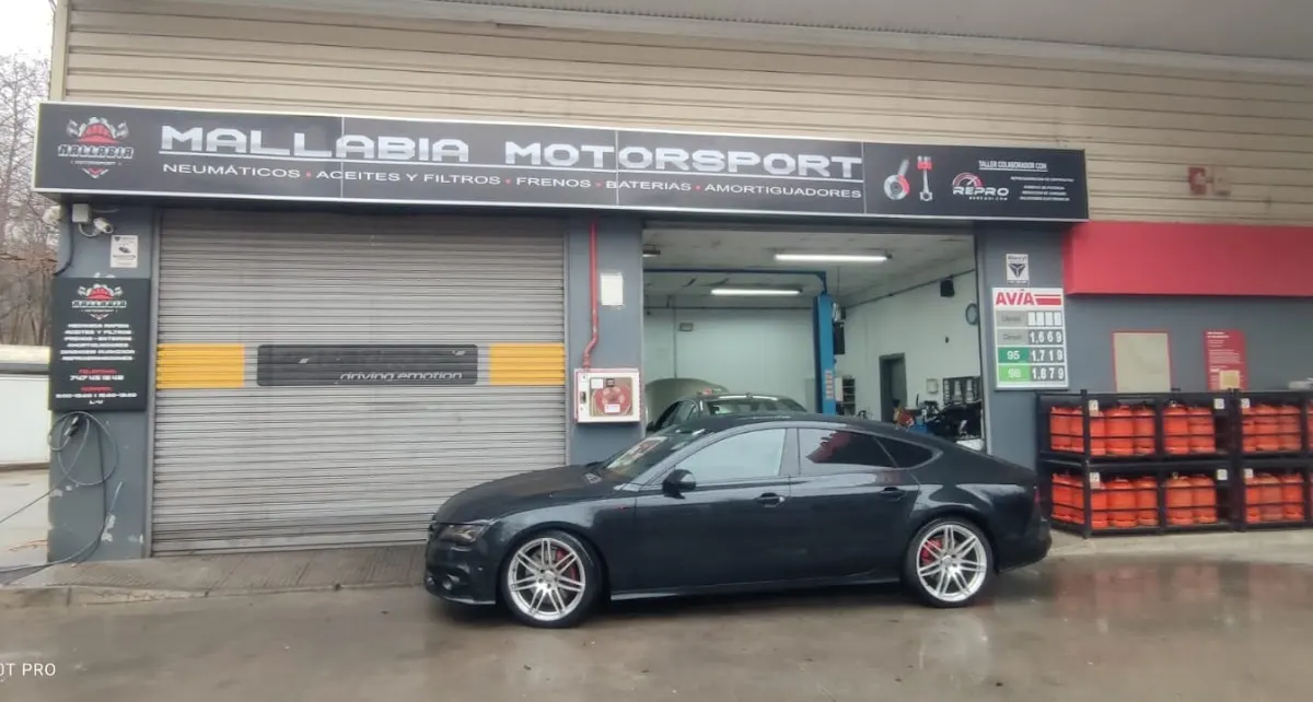 Fachada de Mallabia Motorsport con un coche estacionado frente al taller.