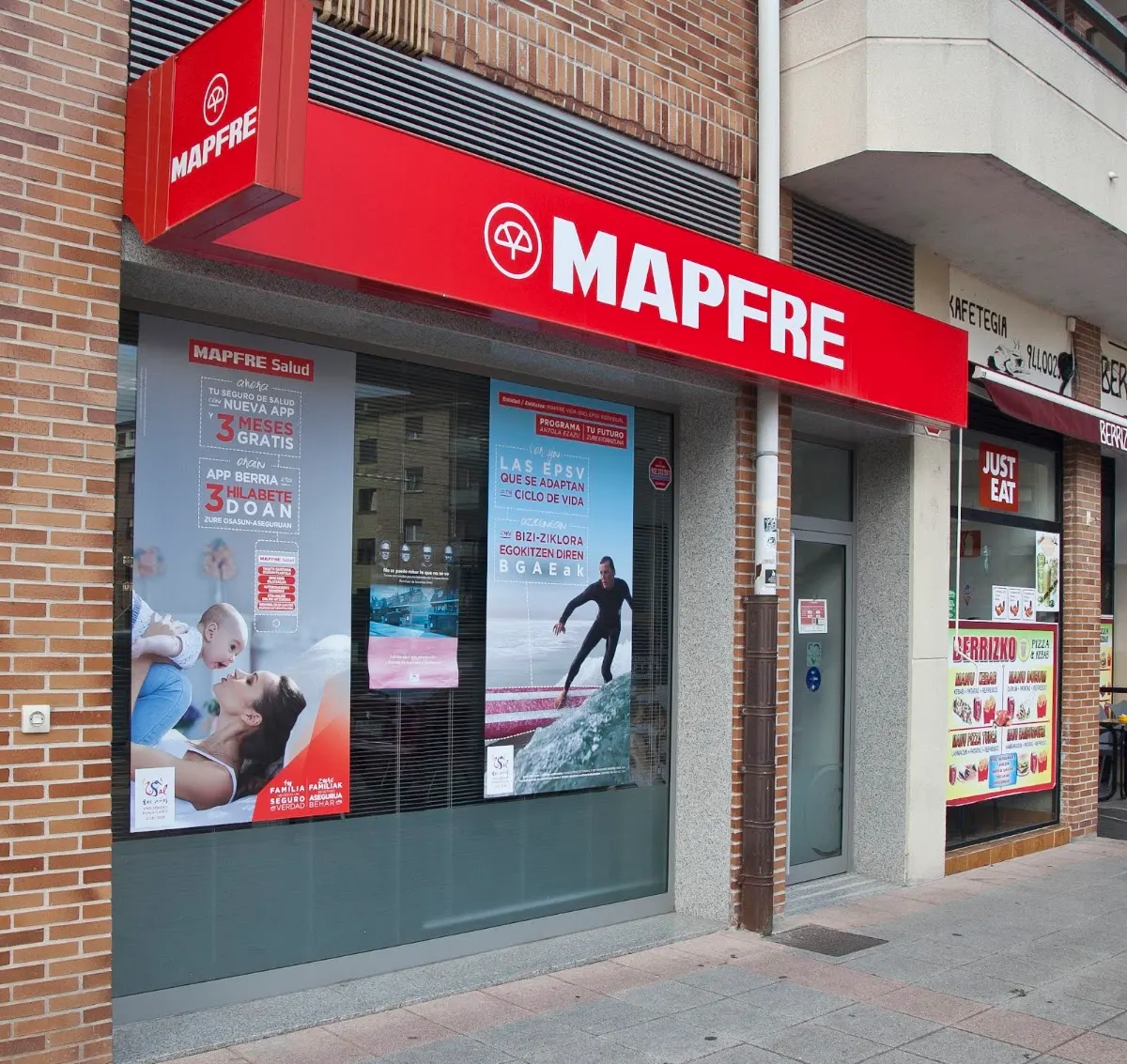 Fachada de la oficina de Mapfre en Berriz, con rótulo rojo y escaparate.