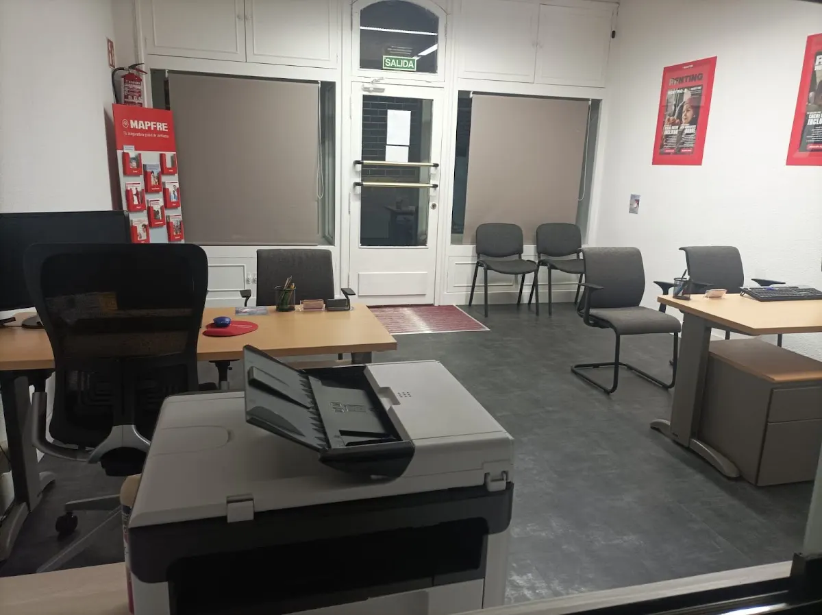 Interior de la oficina de Mapfre, con zona de atención y puestos de trabajo.