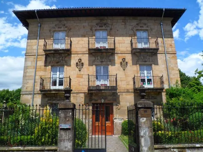 Fachada de piedra y balcones de Maria Bitarteko Ikastetxea en Elorrio
